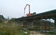 Насос работает на узком действующем автомобильном мосту через реку Вилия