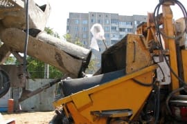 Бетономиксер подает бетон в бункер автобетононасоса